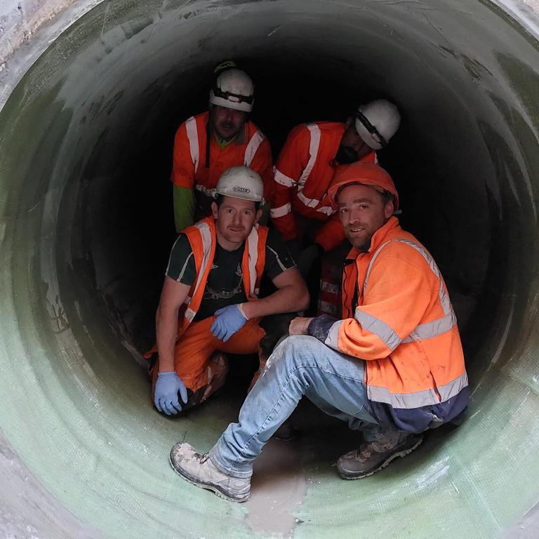 Staff inside a large fiberglass tube